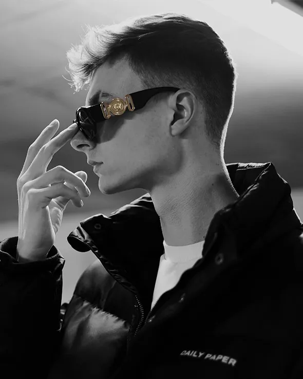 A black and white picture of myself, Jaron Haerens, where I'm wearing a Daily Paper puffer jacket and Versace sunglasses